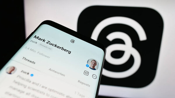 Stuttgart, Germany - 09-21-2023: Smartphone with website of social network Threads (Meta Platforms Inc.) on screen in front of logo. Focus on top-left of phone display.
