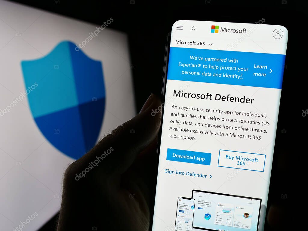 Stuttgart, Germany - 09-21-2023: Person holding cellphone with webpage of security software Microsoft Defender Antivirus on screen with logo. Focus on center of phone display.