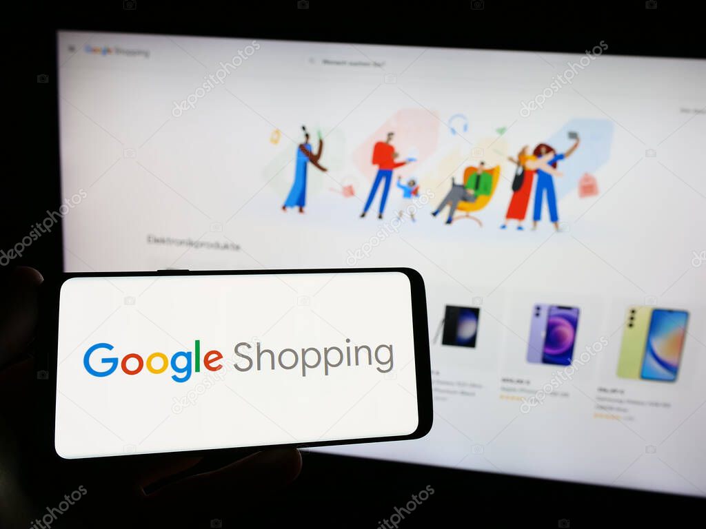 Stuttgart, Germany - 09-23-2023: Person holding smartphone with logo of product search platform Google Shopping on screen in front of website. Focus on phone display.