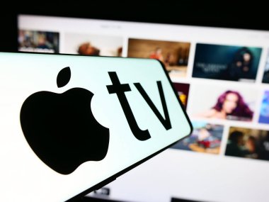 Stuttgart, Almanya - 09-23-2023: Video yayın servisi Apple TV logosuna sahip akıllı telefon artı iş dünyasının web sitesi önünde ekranda. Telefon ekranının merkez soluna odaklan.