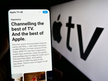 Stuttgart, Almanya - 09-23-2023: Video yayın servisi Apple TV 'nin web sayfası ve logonun önündeki ekranda akıllı telefon tutan kişi. Telefon ekranının merkezine odaklan.