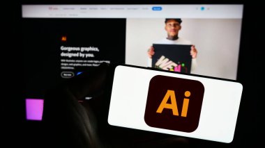 Stuttgart, Almanya - 09-23-2023: Vektör grafik editörü Adobe Illustrator logosuna sahip akıllı telefon sahibi kişi web sitesinin önünde ekranda. Telefon ekranına odaklan.