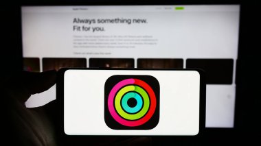 Stuttgart, Almanya - 09-23-2023: Egzersiz izleme uygulaması logosu olan cep telefonu sahibi kişi iş sayfasının önünde ekranda. Telefon ekranına odaklan.