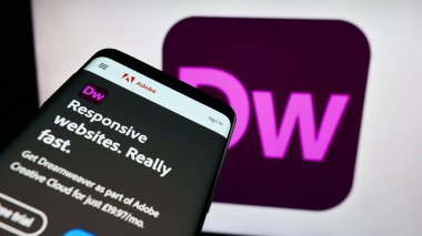 Stuttgart, Almanya - 09-23-2023: İnternet geliştirme yazılımı Adobe Dreamweaver 'ın yer aldığı cep telefonu iş logosu önünde ekranda. Telefon ekranının sol üst kısmına odaklan.