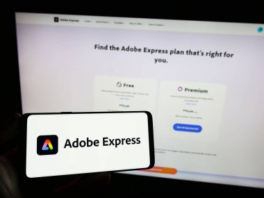 Stuttgart, Almanya - 09-23-2023: Grafik tasarım yazılımı logosu olan cep telefonu sahibi kişi iş sayfasının önünde ekranda. Telefon ekranına odaklan.