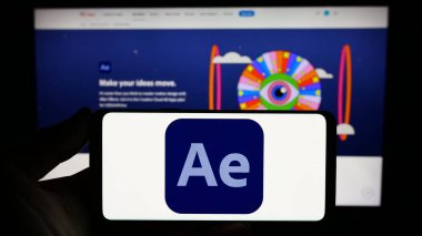 Stuttgart, Almanya - 09-23-2023: İnternet sitesi önünde ekranda Adobe After Effects adlı hareketli grafik yazılımının logosuna sahip akıllı telefonu tutan kişi. Telefon ekranına odaklan.