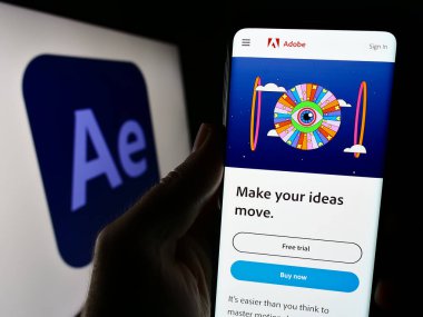 Stuttgart, Almanya - 09-23-2023: Cep telefonu elinde hareket grafik yazılımı Adobe After Effects web sitesi bulunan kişi logo ile ekranda. Telefon ekranının merkezine odaklan.