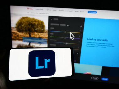 Stuttgart, Almanya - 09-23-2023: Görüntü işleme yazılımı logosu olan cep telefonu şirketinin web sayfası önünde ekranda. Telefon ekranına odaklan.