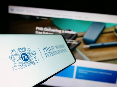 Stuttgart, Almanya - 08-06-2023: İnternet sitesi önünde ekranda Philip Morris International Inc. 'in logosuna sahip akıllı telefon. Telefon ekranının merkez soluna odaklan.