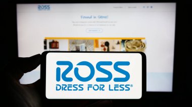 Stuttgart, Almanya - 08-07-2023: ABD 'li perakende şirketi Ross Stores Inc.' in logosuyla cep telefonu sahibi kişi iş sayfasının önünde ekranda. Telefon ekranına odaklan.