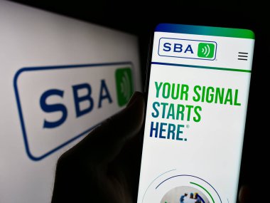 Stuttgart, Almanya - 08-07-2023: ABD 'li şirket SBA Communications Corporation' ın web sayfası olan cep telefonu logosu önünde ekranda. Telefon ekranının merkezine odaklan.