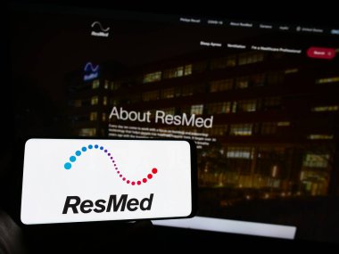 Stuttgart, Almanya - 08-07-2023: Web sitesinin önünde ekranda ABD 'li tıbbi ekipman şirketi ResMed Inc.' in logosuna sahip akıllı telefonu tutan kişi. Telefon ekranına odaklan.