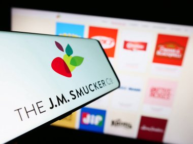 Stuttgart, Almanya - 08-08-2023: Amerikan gıda şirketinin logosuna sahip akıllı telefon The J.M. Smucker Şirketi web sitesinin önünde ekranda. Telefon ekranının merkez soluna odaklan.