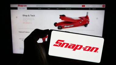 Stuttgart, Almanya - 08-08-2023: ABD 'li araç şirketi Snap-on Anonim Şirketi' nin logosuyla cep telefonu sahibi kişi iş sayfasının önünde ekranda. Telefon ekranına odaklan.