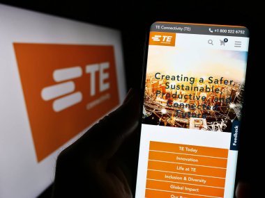 Stuttgart, Almanya - 08-09-2023: İsviçre firması TE Connectivity Ltd. 'nin internet sayfası ile cep telefonu tutan kişi logonun önünde ekranda. Telefon ekranının merkezine odaklan.