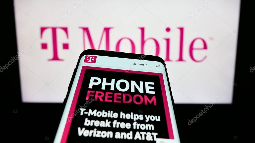 Stuttgart, Germany - 08-09-2023: Mobile phone with web page of telecommunications company T-Mobile US Inc. on screen in front of business logo. Focus on top-left of phone display.