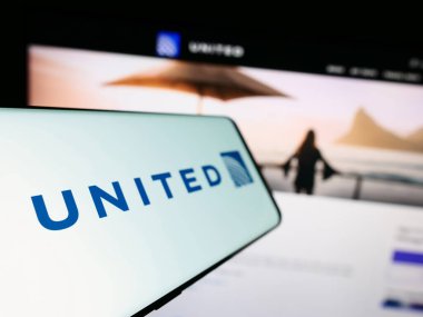 Stuttgart, Almanya - 08-11-2023: Amerikan şirketi United Airlines Holding Inc. 'nin logosuna sahip akıllı telefon, iş dünyasının web sitesinin önünde ekranda. Telefon ekranının soluna odaklan.