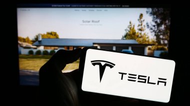 Stuttgart, Almanya - 08-11-2023: ABD 'li otomotiv ve enerji şirketi Tesla Inc.' in logosunu taşıyan cep telefonu iş sayfasının önünde ekranda. Telefon ekranına odaklan.