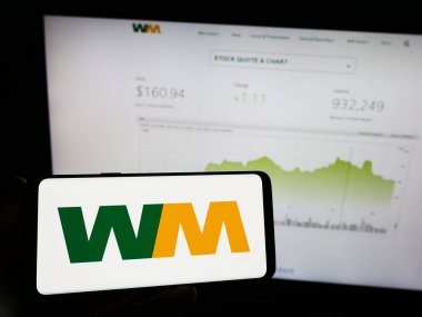Stuttgart, Almanya - 08-12-2023: Amerikan imha şirketi Atık Yönetim A.Ş. 'nin logosunun bulunduğu cep telefonu web sayfasının önünde ekranda. Telefon ekranına odaklan.