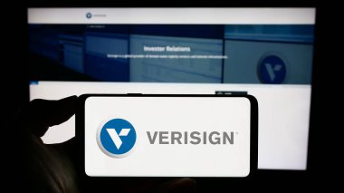 Stuttgart, Almanya - 08-12-2023: Web sayfası önünde ABD ağ altyapı şirketi Verisign Inc. 'in logosuyla cep telefonu tutan kişi. Telefon ekranına odaklan.