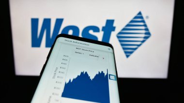 Stuttgart, Almanya - 08-12-2023: İş logosu önünde ekranda ABD 'li West Pharmaceutical Services Inc.' in web sitesi bulunan cep telefonu. Telefon ekranının sol üst kısmına odaklan.