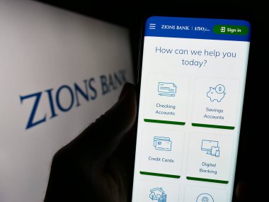 Stuttgart, Almanya - 08-13-2023: ABD 'li bankacılık şirketi Zions Bancorporation N.A.' nın internet sitesiyle cep telefonu tutan kişi Ekranda logo var. Telefon ekranının merkezine odaklan.