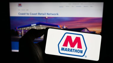 Stuttgart, Almanya - 08-13-2023: ABD 'li petrol şirketi Marathon Petroleum Corporation' ın logosunu elinde tutan kişi web sitesinin önünde ekranda. Telefon ekranına odaklan.