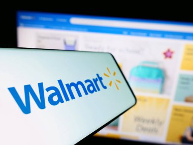 Stuttgart, Almanya - 08-13-2023: Amerikan perakende şirketi Walmart Inc. 'in logosuna sahip akıllı telefon iş sitesinin önünde ekranda. Telefon ekranının merkez soluna odaklan.