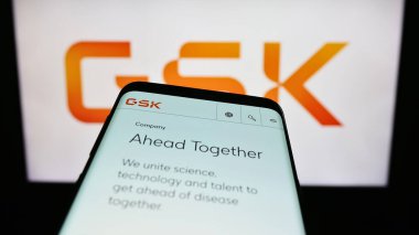 Stuttgart, Almanya - 08-13-2023: İngiliz ilaç şirketi GSK plc 'nin web sitesine sahip akıllı telefon iş logosu önünde ekranda. Telefon ekranının sol üst kısmına odaklan.