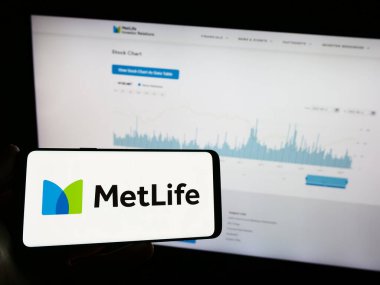 Stuttgart, Almanya - 08-13-2023: Amerikan sigorta şirketi MetLife Inc. 'in logosunun bulunduğu cep telefonu sahibi kişi iş sayfasının önünde ekranda. Telefon ekranına odaklan.
