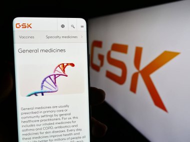 Stuttgart, Almanya - 08-13-2023: İngiliz ilaç şirketi GSK plc 'nin web sayfası olan cep telefonu logonun önünde ekranda. Telefon ekranının merkezine odaklan.