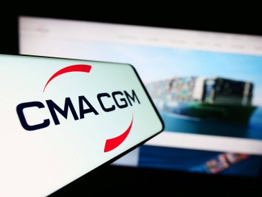 Stuttgart, Germany - 08-13-2023: Cellphone with logo of French logistics company CMA CGM S.A. on screen in front of business website. Focus on center-left of phone display. clipart