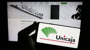 Stuttgart, Almanya - 08-13-2023: İspanyol bankacılık şirketi Unicaja Banco S.A. 'nın logosunun bulunduğu akıllı telefon web sitesi önünde ekranda. Telefon ekranına odaklan.