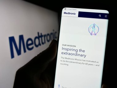 Stuttgart, Almanya - 08-14-2023: Tıbbi teknoloji şirketi Medtronic plc 'in web sayfası olan cep telefonu logonun önünde ekranda. Telefon ekranının merkezine odaklan.