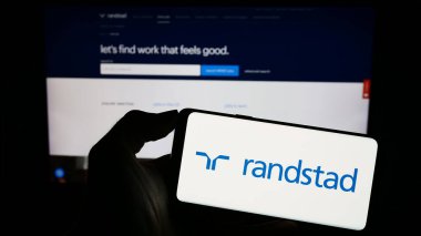 Stuttgart, Almanya - 08-14-2023: Hollandalı insan kaynakları şirketi Randstad NV 'nin logosunun bulunduğu cep telefonu web sayfası önünde ekranda. Telefon ekranına odaklan.