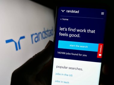 Stuttgart, Almanya - 08-14-2023: Hollandalı insan kaynakları şirketi Randstad N.V. 'nin web sayfalı akıllı telefon iş logosu önünde ekranda. Telefon ekranının merkezine odaklan.