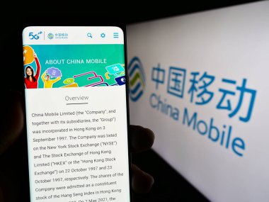 Stuttgart, Almanya - 08-14-2023: Telekomünikasyon şirketi China Mobile Limited 'in web sayfası ile cep telefonu tutan kişi logolu ekranda. Telefon ekranının merkezine odaklan.