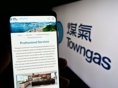 Stuttgart, Almanya - 08-16-2023: The Hong Kong and China Gas Co. Ltd. (Towngas) adlı bir web sitesi bulunan kişi ekranda logo ile görüntüleniyor. Telefon ekranının merkezine odaklan.