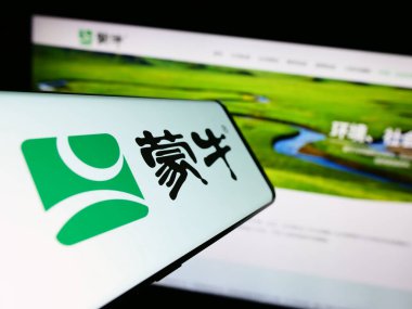 Stuttgart, Almanya - 08-16-2023: Çinli Mengniu Dairy Company 'nin logosunun yer aldığı akıllı telefon, işletme web sitesi önünde ekranda. Telefon ekranının merkezine odaklan.