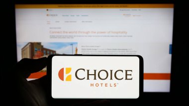 Stuttgart, Almanya - 08-18-2023: ABD 'li firma Choice Hotels International Inc.' in logosuyla cep telefonu sahibi kişi iş sayfasının önünde ekranda. Telefon ekranına odaklan.