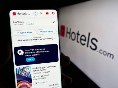 Stuttgart, Almanya - 08-18-2023: ABD 'li otel rezervasyon şirketi Hotels.com LP' nin web sayfası olan cep telefonu sahibi kişi logonun önünde ekranda. Telefon ekranının merkezine odaklan.