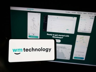 Stuttgart, Almanya - 08-18-2023: ABD 'li esrar teknoloji şirketi Weedmaps' in logosunu elinde tutan kişi web sitesinin önünde ekranda. Telefon ekranına odaklan.