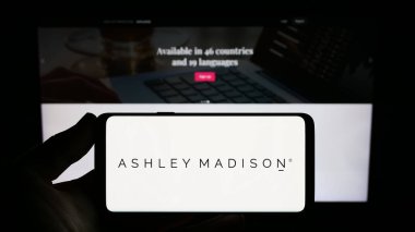 Stuttgart, Almanya - 08-18-2023: İnternet sitesi önünde ekranda Ashley Madison Ajansı 'nın logosuna sahip kişi. Telefon ekranına odaklan.