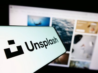 Stuttgart, Almanya - 08-18-2023: Stok fotoğraf şirketi Unsplash Inc. 'in logosu olan cep telefonu iş dünyasının web sitesinin önünde ekranda. Telefon ekranının merkez soluna odaklan.