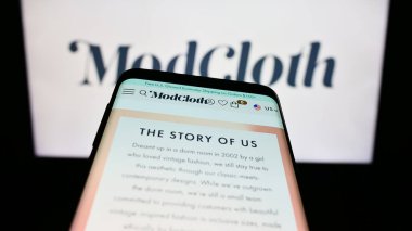 Stuttgart, Almanya - 08-20-2023: ABD 'li e-ticaret şirketi ModCloth' un web sitesi olan cep telefonu iş logosu önünde ekranda. Telefon ekranının sol üst kısmına odaklan.
