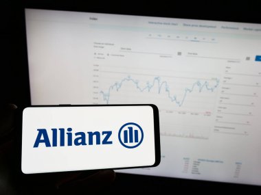 Stuttgart, Almanya - 08-20-2023: Alman sigorta şirketi Allianz SE 'nin logosuyla cep telefonu sahibi kişi iş sayfasının önünde ekranda. Telefon ekranına odaklan.