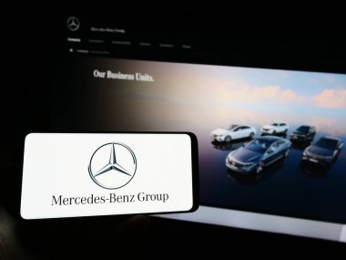 Stuttgart, Almanya - 08-20-2023: Otomotiv şirketi Mercedes-Benz Group AG 'nin logosuna sahip cep telefonu web sayfası önünde ekranda. Telefon ekranına odaklan.