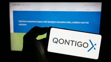 Stuttgart, Almanya - 08-20-2023: Alman finans veri şirketi Qontigo GmbH 'in logosuyla cep telefonu sahibi kişi iş sayfasının önünde ekranda. Telefon ekranına odaklan.