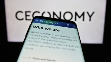 Stuttgart, Almanya - 08-21-2023: Alman perakende şirketi Ceconomy AG 'nin web sitesi ile cep telefonu iş logosu önünde ekranda. Telefon ekranının sol üst kısmına odaklan.