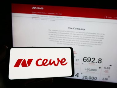Stuttgart, Almanya - 08-21-2023: Baskı şirketi CEWE Stiftung Co. KGaA 'nın logosuna sahip kişi web sitesinin önünde ekranda. Telefon ekranına odaklan.